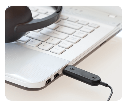 Logitech H340 USB headset connected to a laptop, ideal for school headphones and online learning.