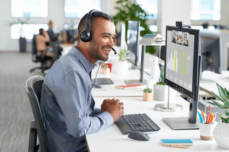 Man using Logitech H390 USB headset at desk, ideal for bulk school headphones and education use.