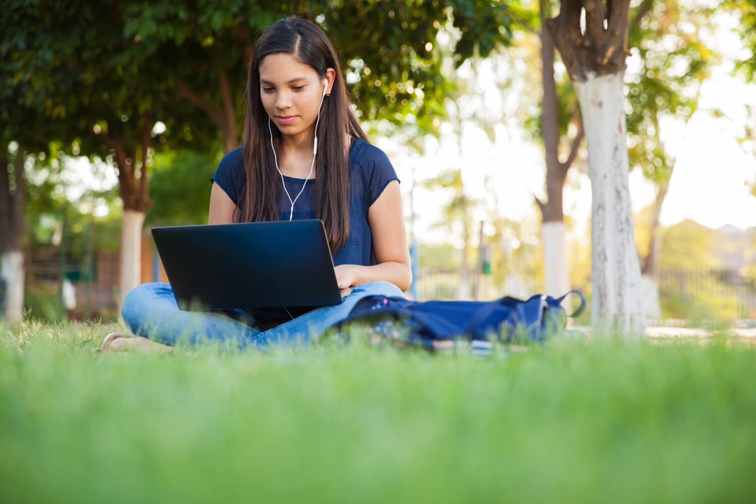 students on mobile device with school headphones and school earbuds