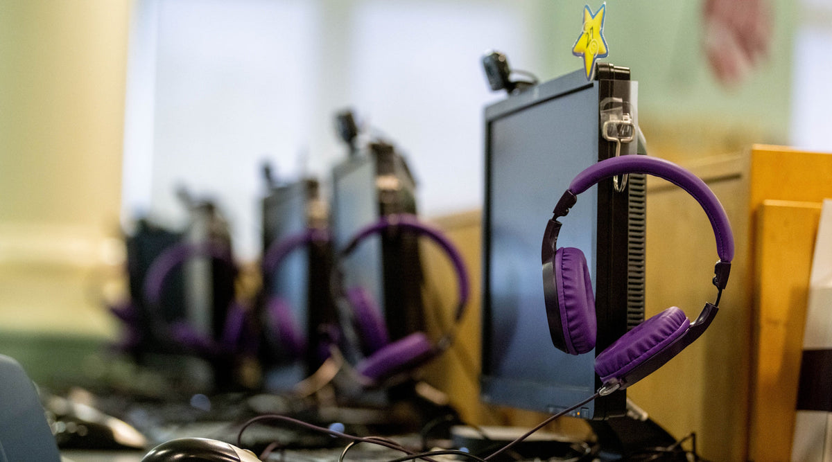 Row of student headphones hanging from tablets in a school computer lab