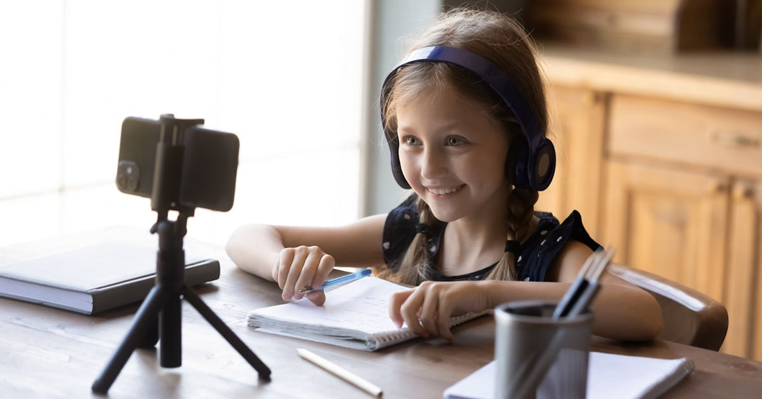 Student wearing over-ear school headphones while participating in an online learning activity at home