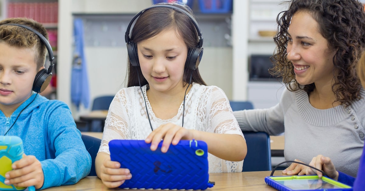 Students using school headphones for independent learning in a classroom