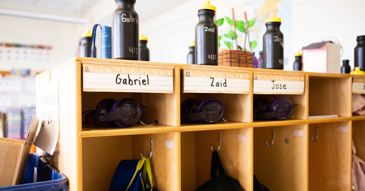 Organized classroom storage with labeled cubbies and headphones for shared school audio equipment