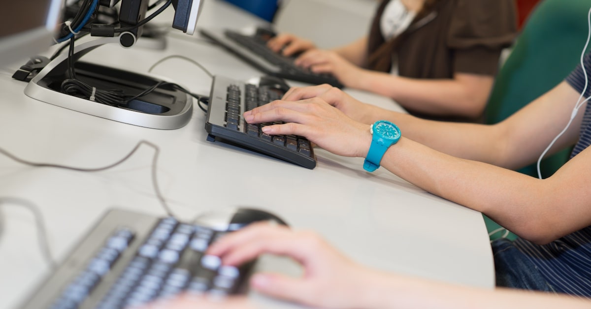 students using earbuds in classroom on computers