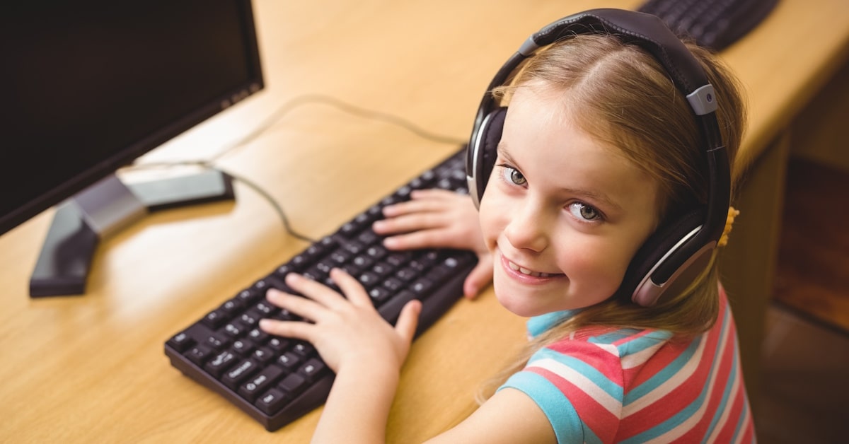 Student wearing testing headphones while using a computer for school assessment