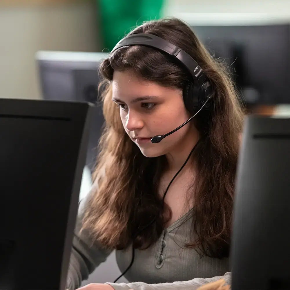 Student wearing the AVID AE-55 headset at a computer