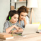 Child using green SchoolMate HA2 headphones at a computer
