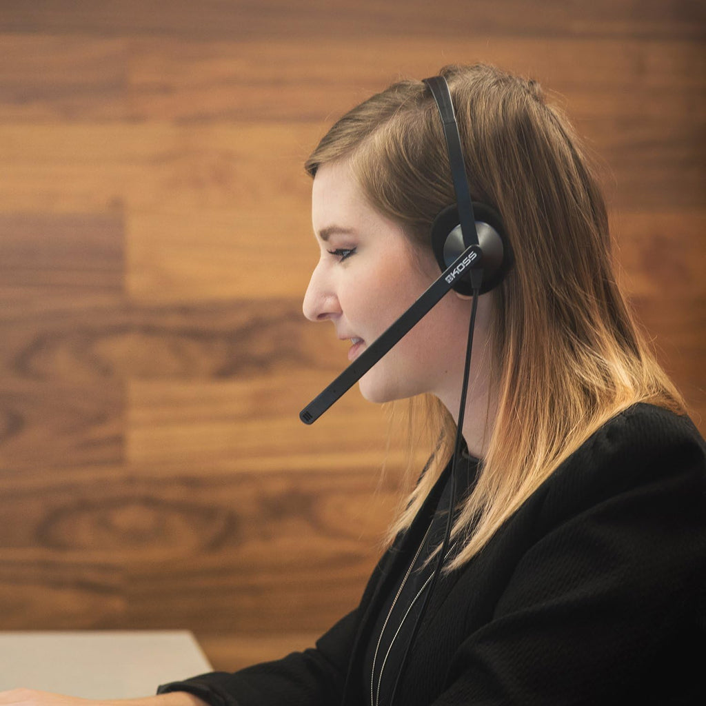 Woman using Koss CS200-USB headset, ideal for school headphones, bulk headphone pack for education, and clear communication.