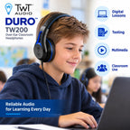 A boy wearing black and blue TWT Audio Duro TW200 over-ear classroom headphones sits at a desk using a laptop in a bright classroom. The image includes promotional text for the headphones and feature icons for digital lessons, testing, multimedia, and classroom use.