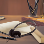 Disposable on-ear headphones on a desk with books, ideal for bulk school headphone needs in educational settings.