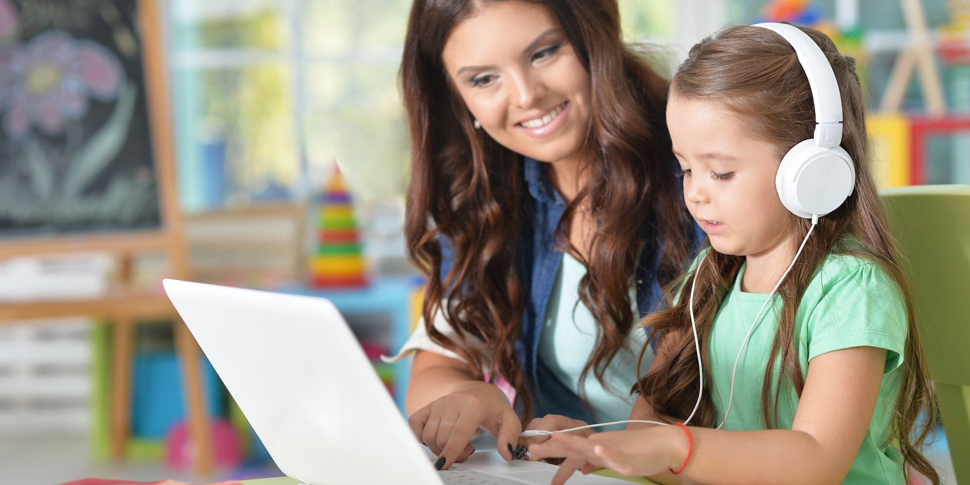 Teacher helping a student use school headphones for classroom learning