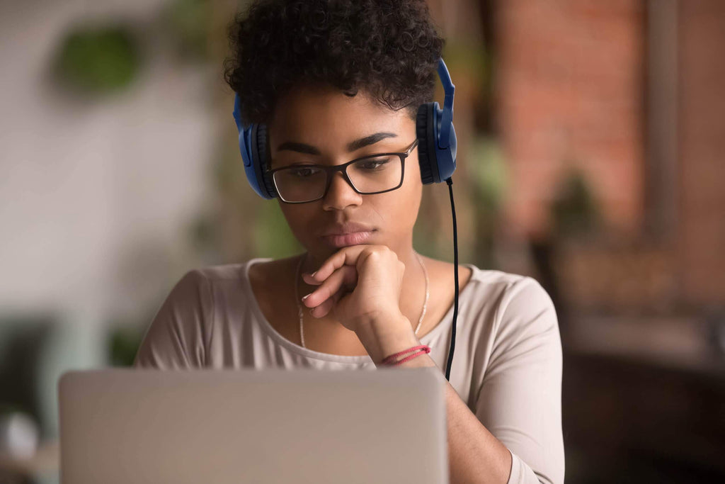 AE-54 Classroom Headphones - Blue worn by a student focused on a laptop.