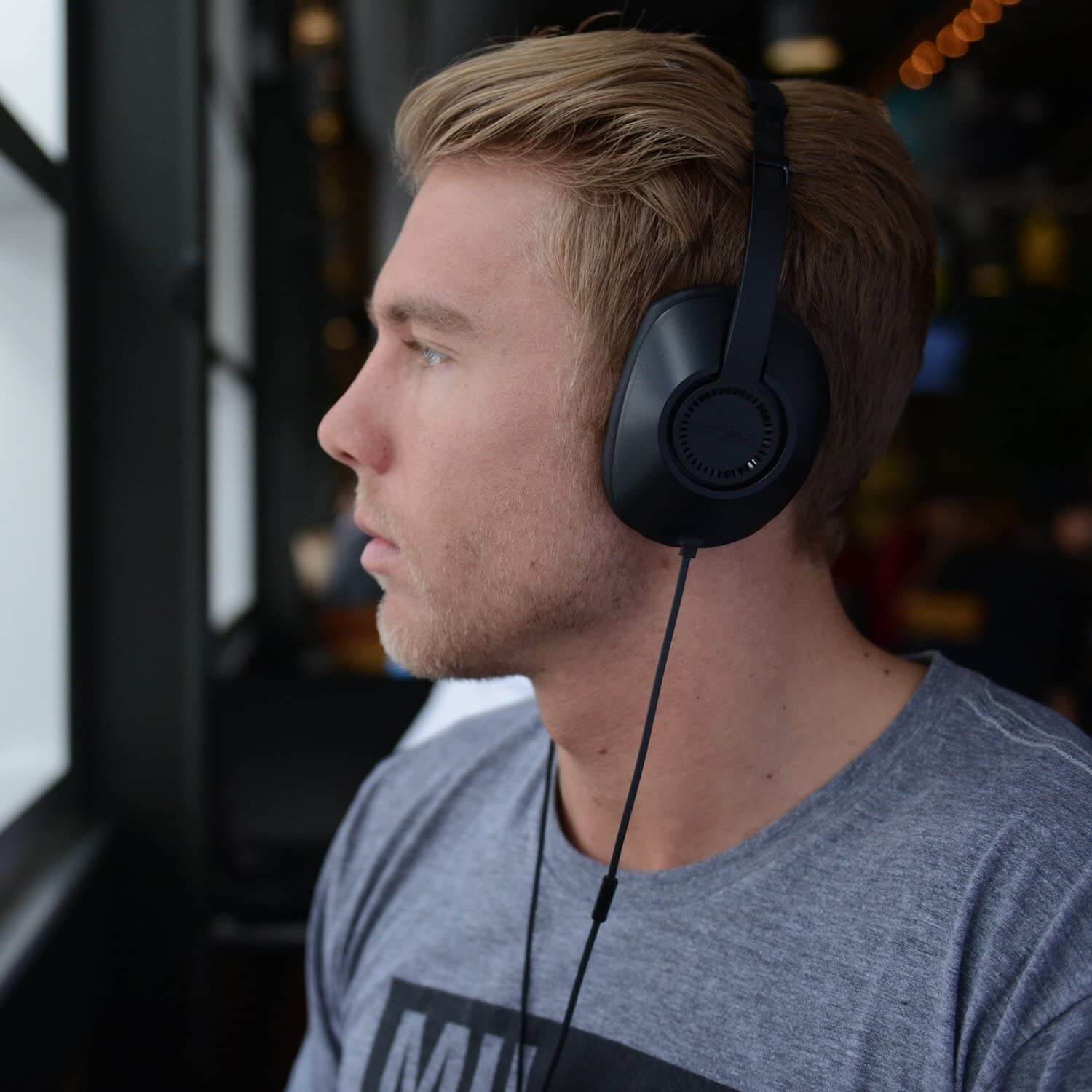 Man wearing Koss UR23i over ear headphones, ideal for bulk school headphones and education use.