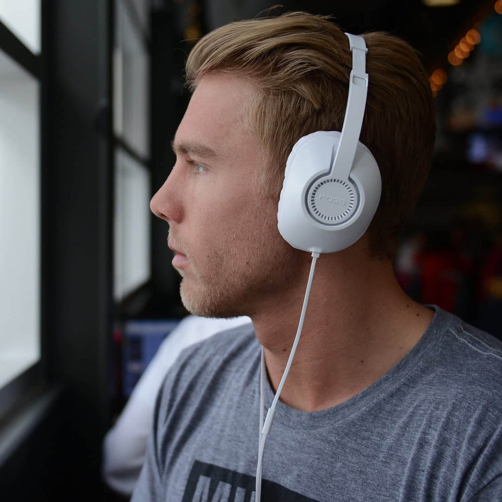 Koss UR23i over ear headphones worn by a young man, ideal bulk school headphones for immersive education listening.