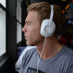 Koss UR23i over ear headphones worn by a young man, ideal bulk school headphones for immersive education listening.