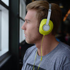 Man wearing bright yellow Koss UR23i headphones, ideal for bulk school headphones and education use.